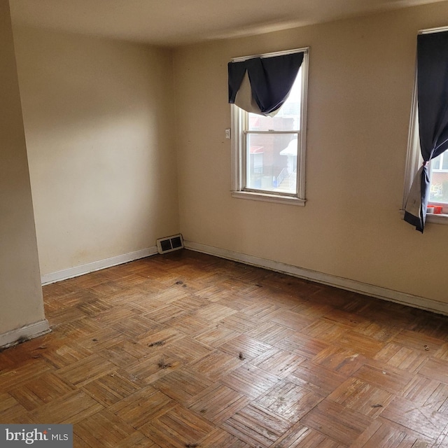 empty room with baseboards and visible vents