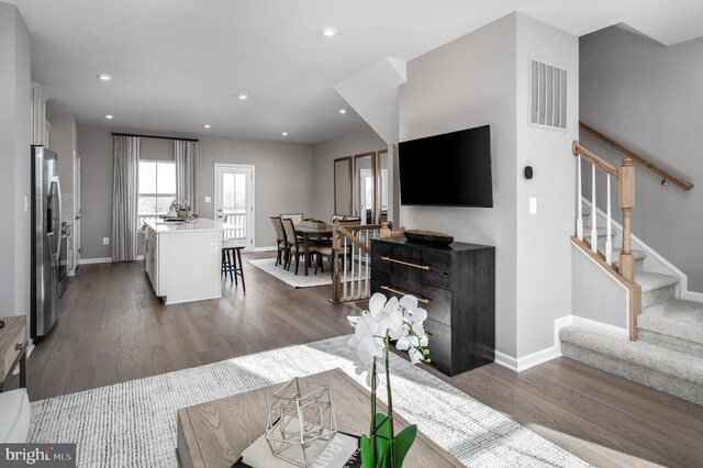 living area featuring stairs, dark wood-style flooring, visible vents, and recessed lighting