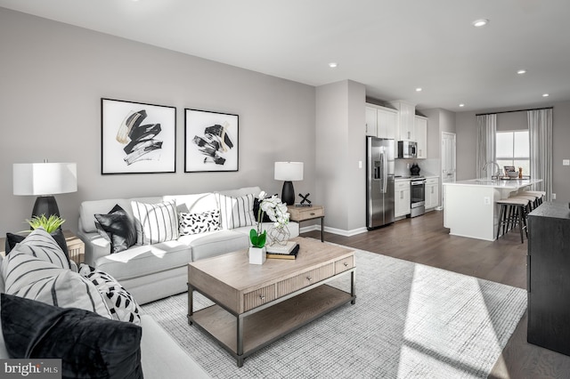 living area with recessed lighting, dark wood finished floors, and baseboards