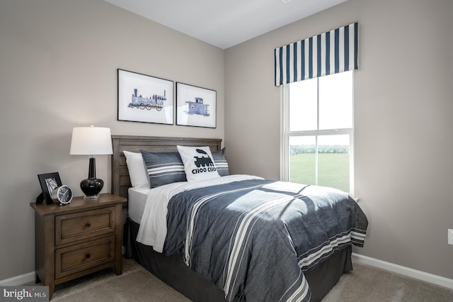 bedroom with baseboards and light colored carpet