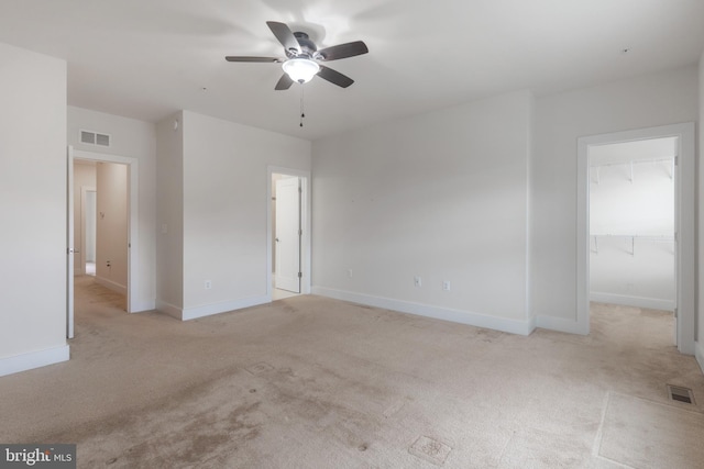 unfurnished bedroom with visible vents, a walk in closet, and baseboards