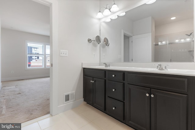 bathroom with a sink, visible vents, tiled shower, and double vanity