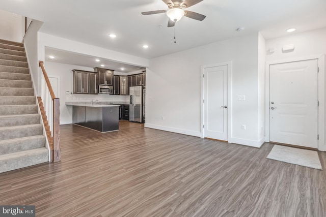 unfurnished living room featuring recessed lighting, stairs, ceiling fan, and wood finished floors