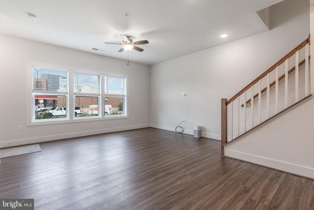 unfurnished living room featuring visible vents, baseboards, ceiling fan, dark wood finished floors, and stairs