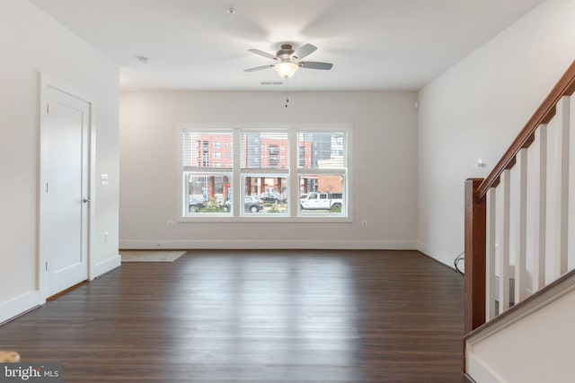 unfurnished living room with stairway, baseboards, wood finished floors, and a ceiling fan