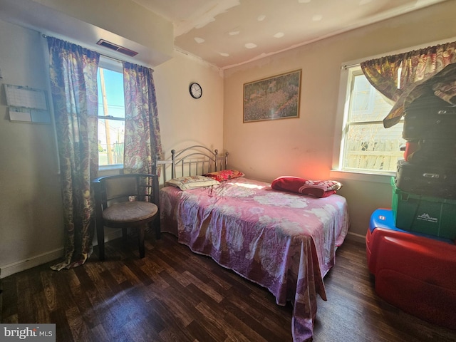 bedroom with multiple windows, wood finished floors, and visible vents