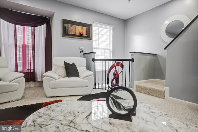 sitting room with an upstairs landing, baseboards, and carpet