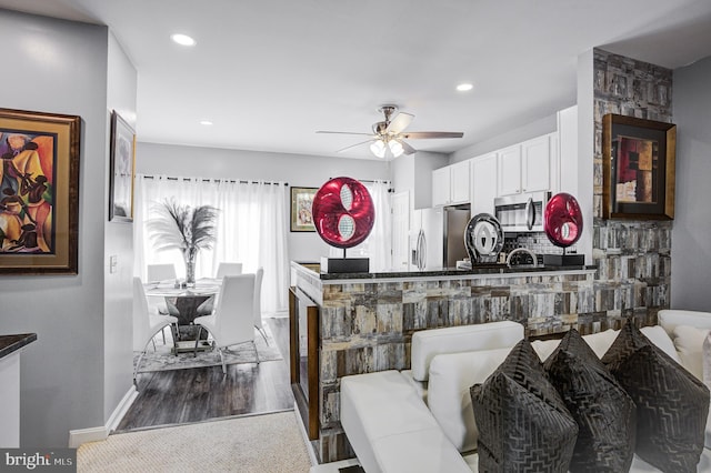 interior space featuring recessed lighting, ceiling fan, stainless steel appliances, white cabinets, and tasteful backsplash