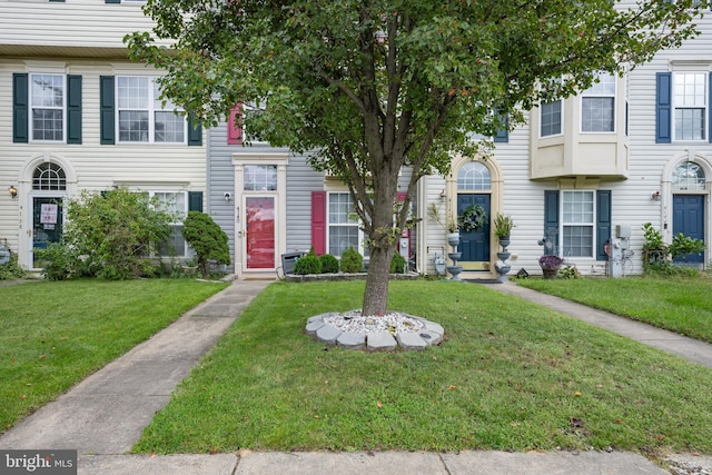 townhome / multi-family property featuring a front lawn