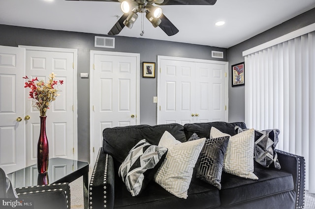 living room with a ceiling fan and visible vents