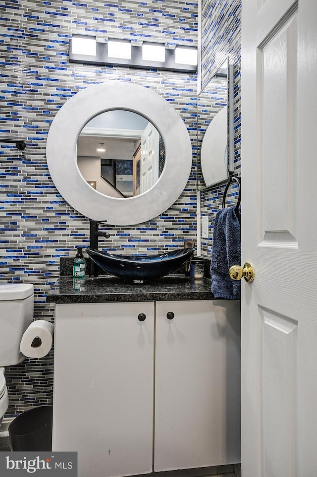 bathroom featuring decorative backsplash, toilet, and vanity