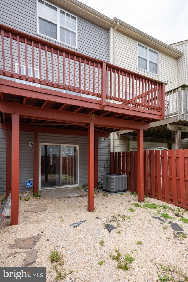 rear view of house featuring central AC and fence