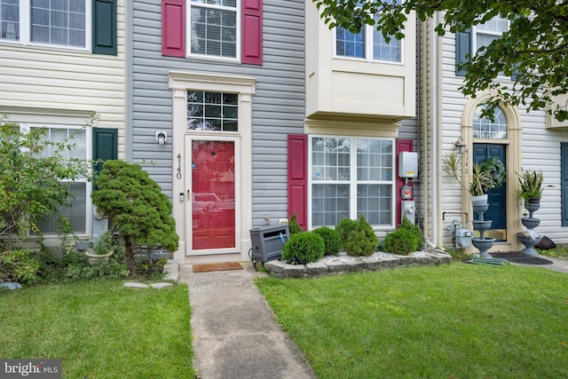 view of exterior entry with a lawn