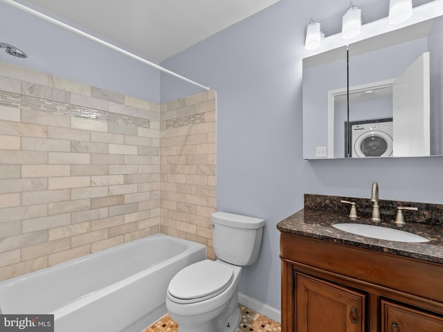 full bathroom featuring toilet, bathing tub / shower combination, vanity, baseboards, and washer / clothes dryer