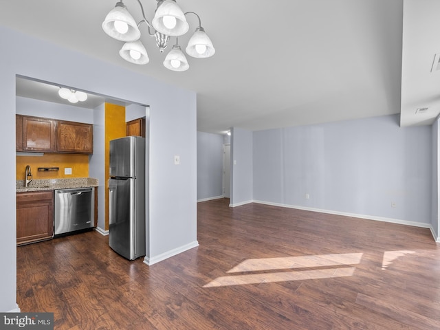 kitchen with baseboards, visible vents, dark wood-style flooring, stainless steel appliances, and a sink