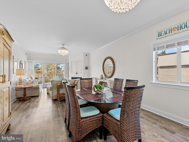 dining room with a chandelier, wood finished floors, and crown molding