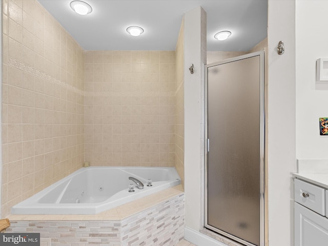 bathroom featuring a stall shower, vanity, and a whirlpool tub