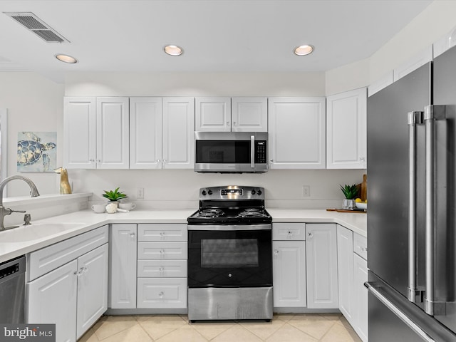 kitchen featuring stainless steel appliances, light countertops, visible vents, white cabinetry, and a sink