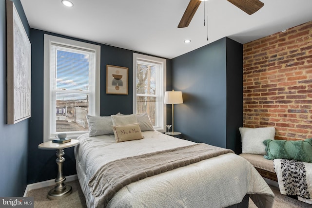 bedroom featuring multiple windows, brick wall, an accent wall, and carpet floors