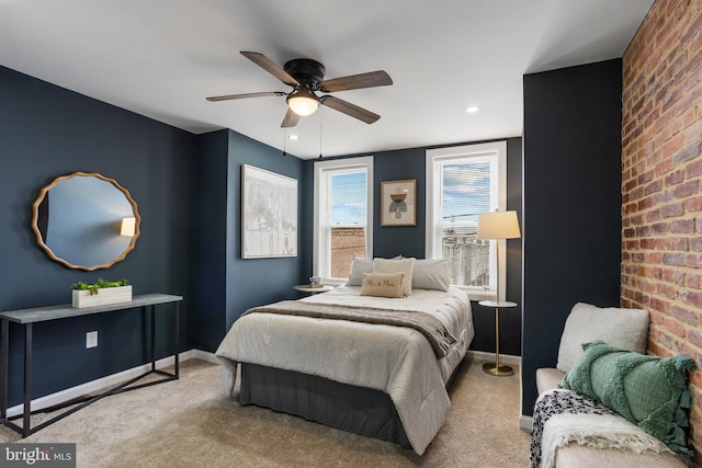 bedroom featuring ceiling fan, baseboards, carpet floors, and brick wall