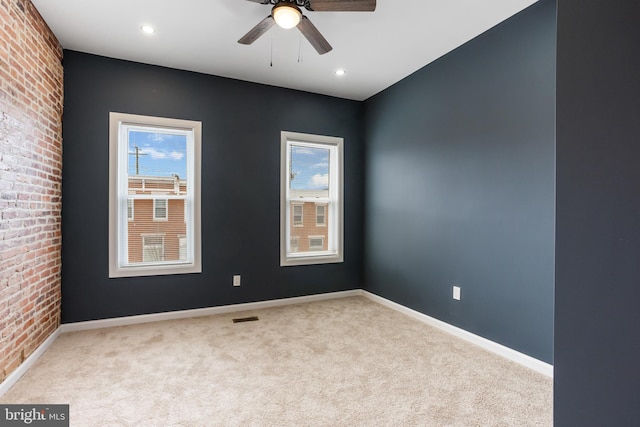 carpeted spare room with baseboards, visible vents, and a wealth of natural light