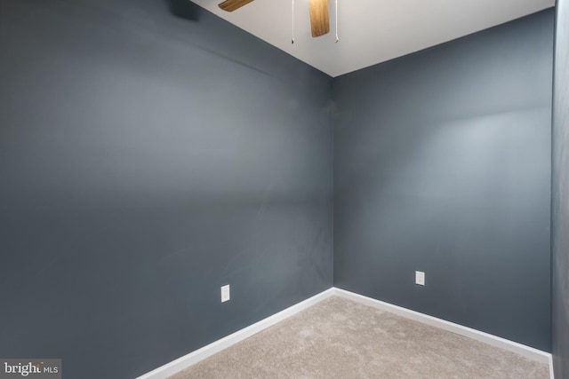 carpeted empty room featuring ceiling fan and baseboards