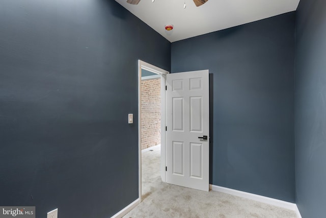 empty room featuring baseboards, light carpet, and ceiling fan