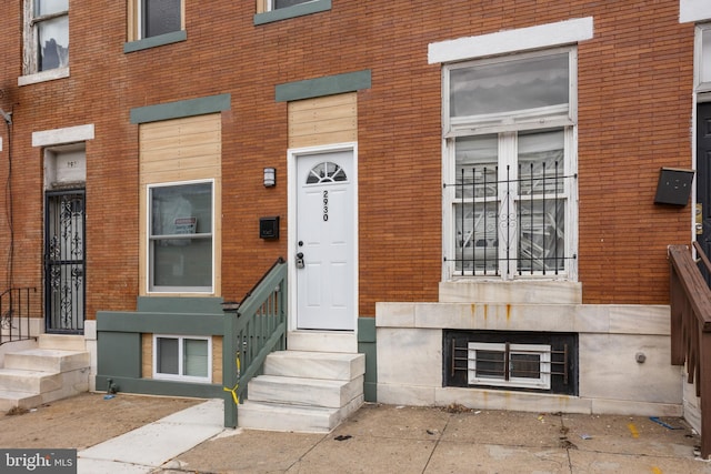 view of exterior entry featuring brick siding