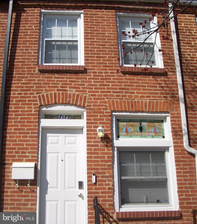 doorway to property with brick siding