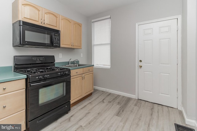 kitchen with visible vents, light wood-style flooring, light brown cabinetry, a sink, and black appliances