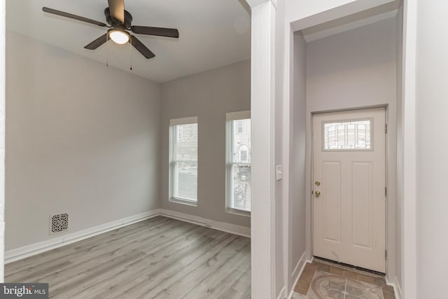 foyer featuring ceiling fan, baseboards, and wood finished floors