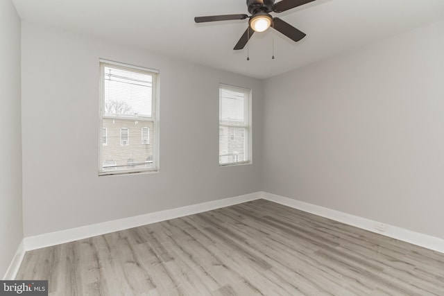 empty room featuring ceiling fan, baseboards, and wood finished floors