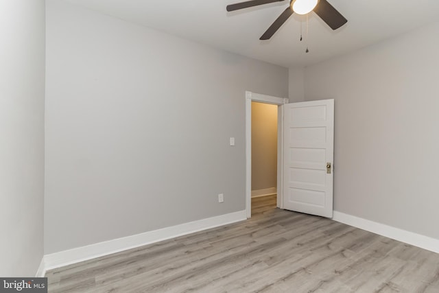 spare room with a ceiling fan, baseboards, and wood finished floors