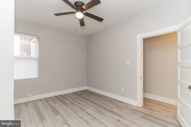 empty room with ceiling fan, wood finished floors, and baseboards