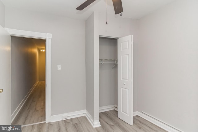 unfurnished bedroom featuring light wood finished floors, ceiling fan, baseboards, and a closet