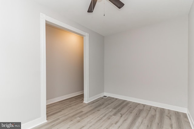 unfurnished room with wood finished floors, a ceiling fan, and baseboards