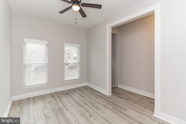 spare room with light wood-style floors, ceiling fan, and baseboards