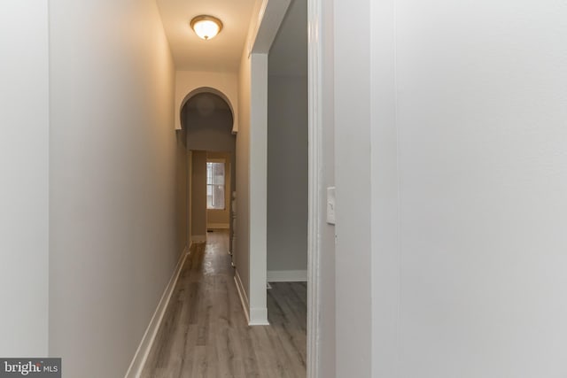 corridor featuring light wood-style floors and baseboards