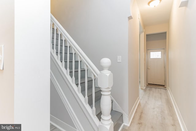 staircase featuring wood finished floors and baseboards