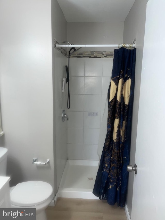 full bath with baseboards, a shower stall, and toilet