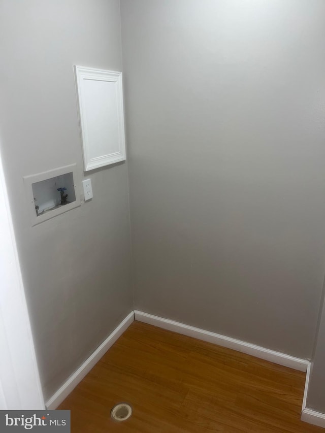 laundry area featuring hookup for a washing machine, baseboards, laundry area, and wood finished floors