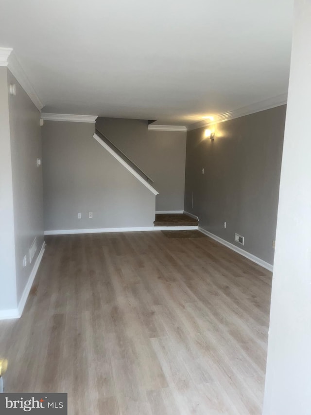 interior space with stairs, baseboards, crown molding, and wood finished floors