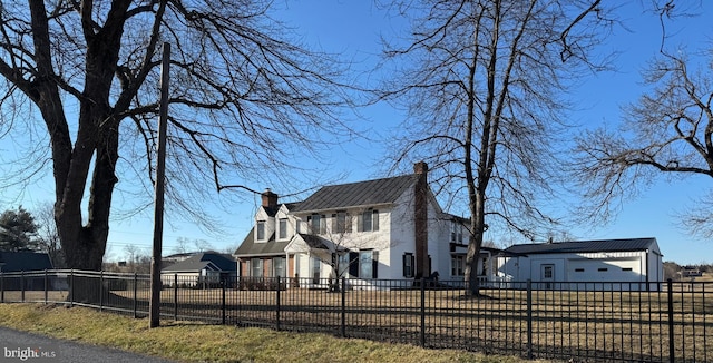 view of side of property with a fenced front yard and a chimney