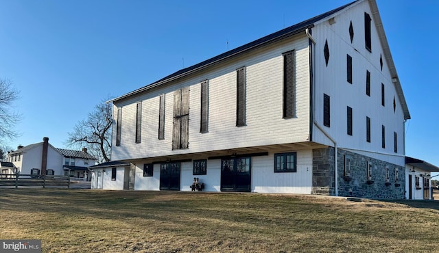 exterior space with stone siding and a front lawn