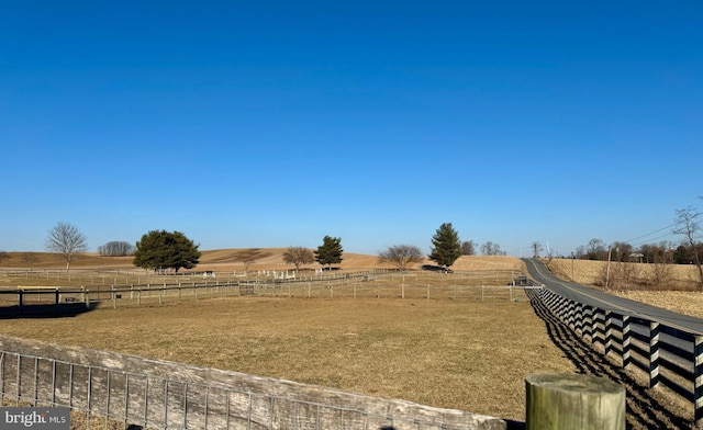 view of yard with a rural view and fence