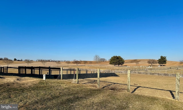 view of yard with an enclosed area and a rural view