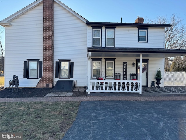 view of front facade with a chimney and a porch