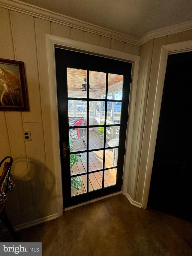 doorway featuring crown molding and a decorative wall