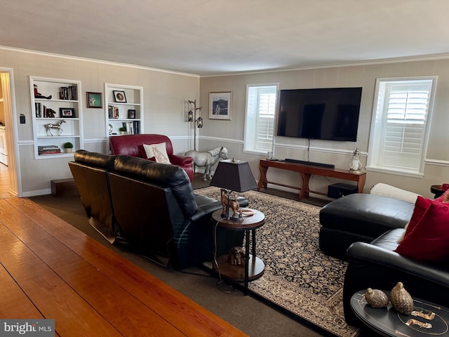 living area featuring built in shelves, ornamental molding, and wood finished floors