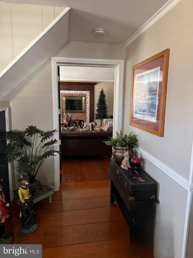 corridor featuring ornamental molding and hardwood / wood-style floors